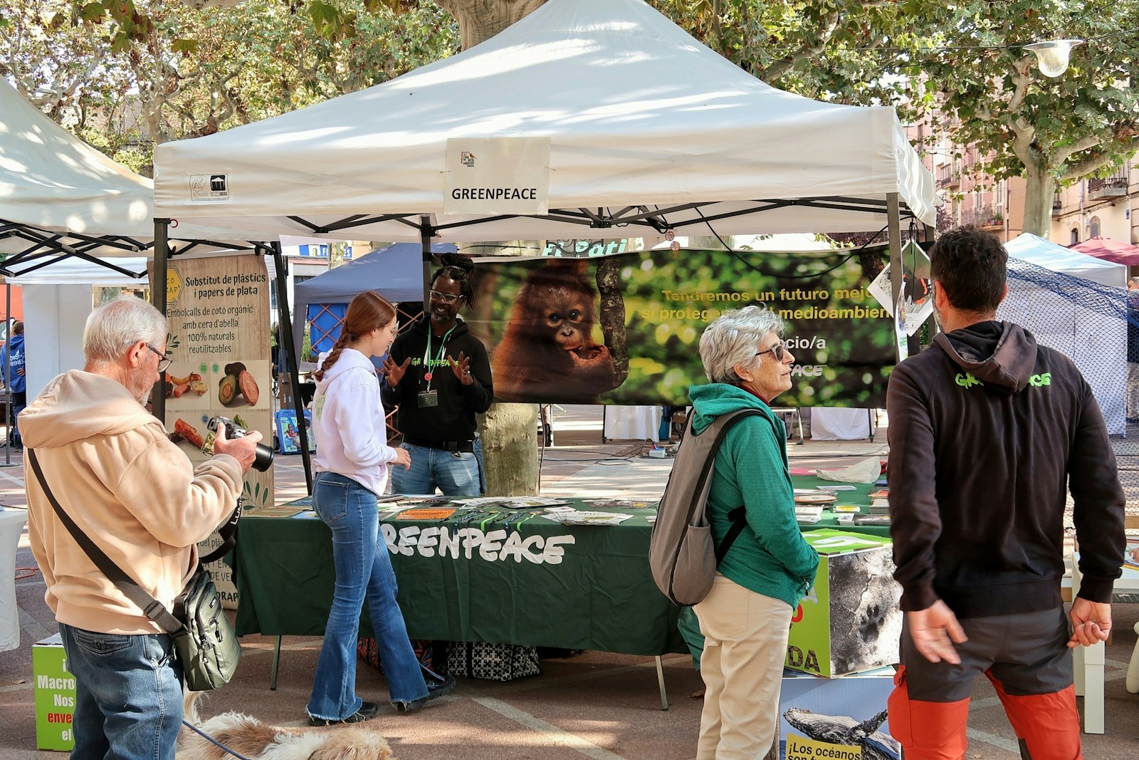 Des gens à un stand d’événement en plein air Greenpeace